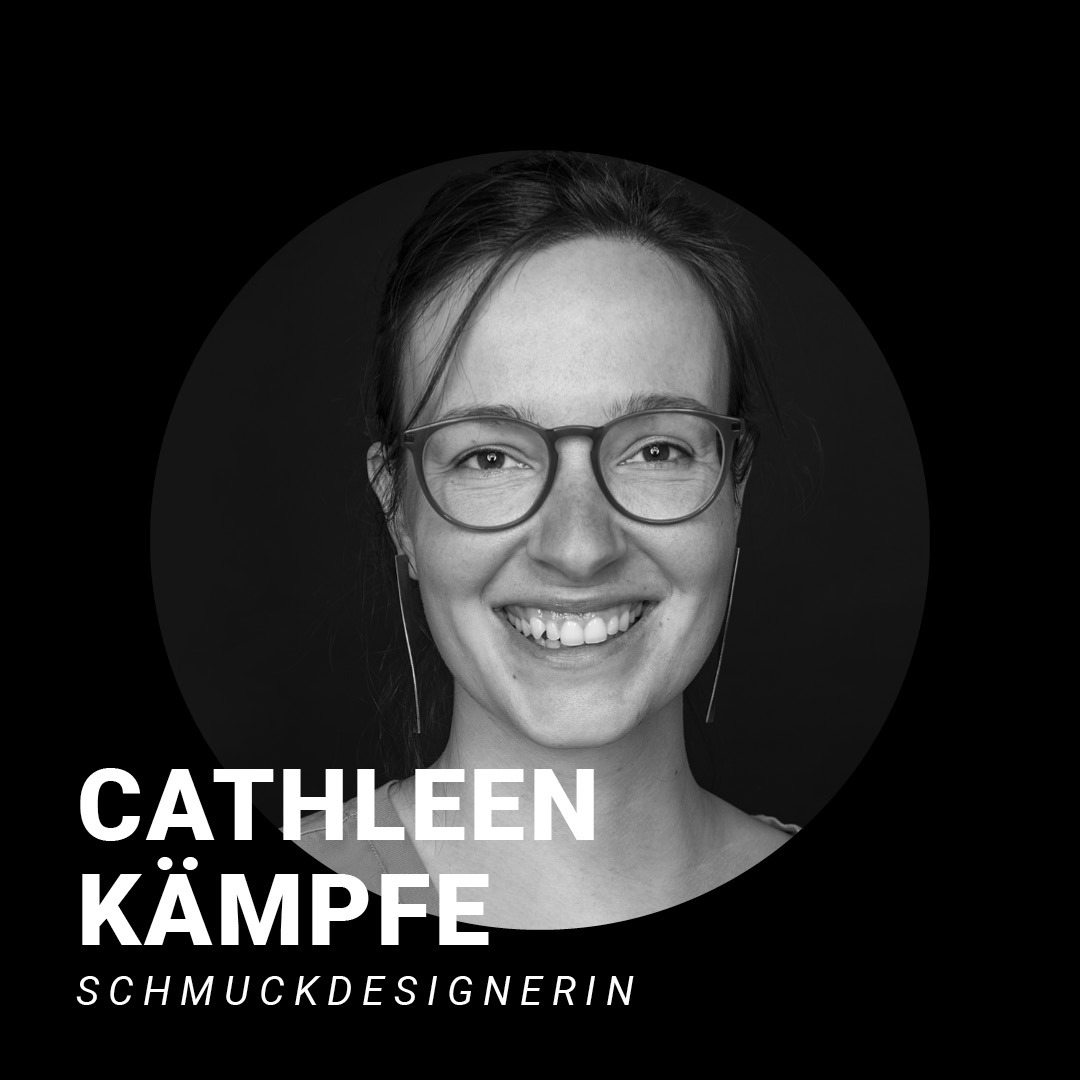 Schwarz weißes Foto einer lachenden Frau mit Brille. Schriftzug: Cathleen Kämpfe, Schmuckdesignerin